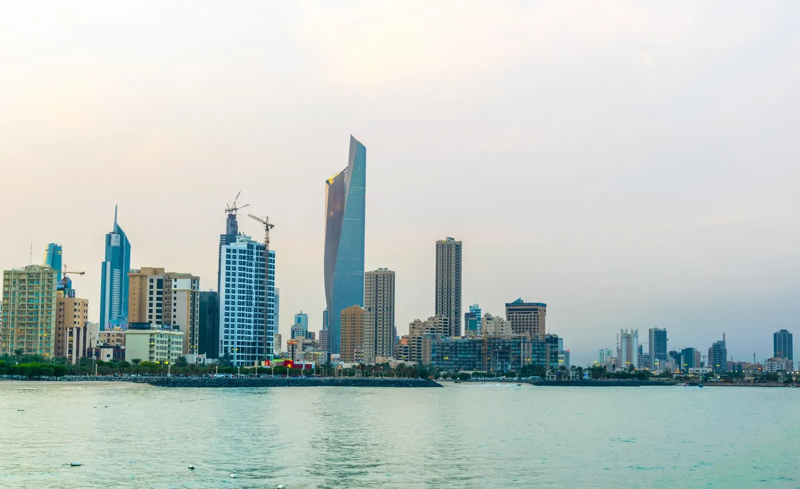 Kuwait City skyline with Al Hamra Tower across the water at sunset